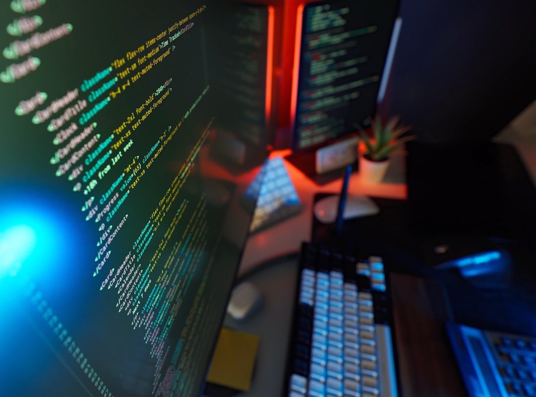 About Cyber coding remote workstation digital studio with colorful color lights, code on screen and modern peripherals. Concept of futuristic remote job, IT support, tech knowledge and software development